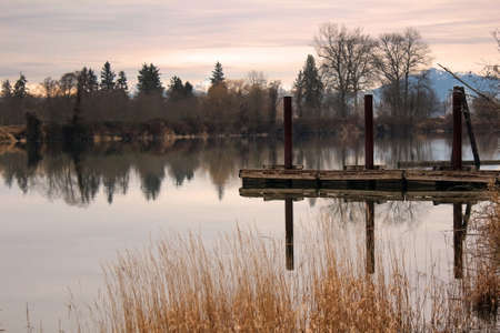 Boat Jetty on still river with reflections