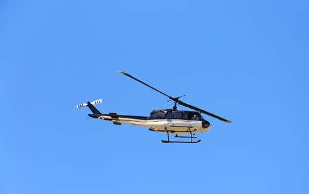 A helicopter in flight with blue skyのeditorial素材