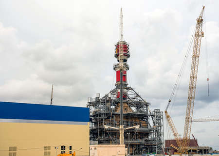 Crane doing a heavy lift of a stack section during power plant construction