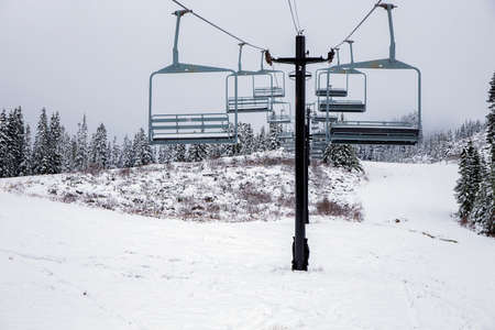 Ski lift with chairs on snowy slope