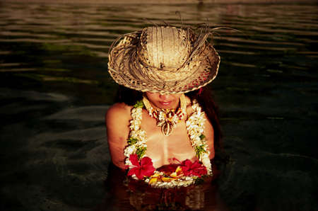 Sexy Woman sitting on a Polynesian Beach at Sunsetの写真素材