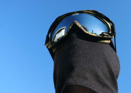 Masked Snowboarder on Blue sky background