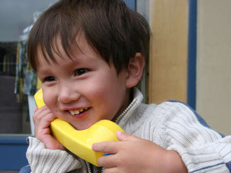 Smiling mixed Asian Caucasian 2 years old toddler calling homeの写真素材