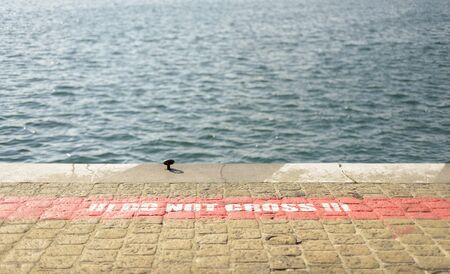 warning paint on the dock floor, do not crossの写真素材