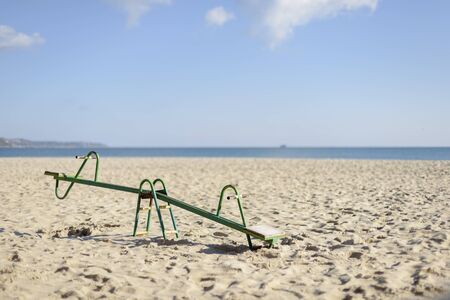 Isolated old green swing  on the beach