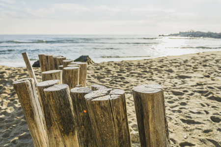 Wooden post on the beach leading ti the sea , blue sky with clouds, の写真素材