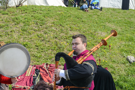 VELIKO TARNOVO, APRIL 04 2015, a man playing music with a bagpipe lot of tourist are around him a listeningのeditorial素材