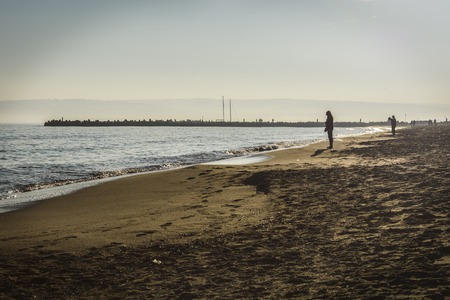 Silhouette of unknown people on the beachの写真素材