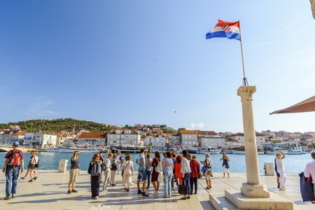 SPLIT, CROATIA, OCTOBER 01, 2017: tourist walking on the waterfront and taking picture of the Split marina near the Croatian flagのeditorial素材