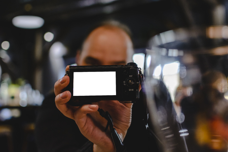 unknown blurry man holding a camera with blank space for text on screenの写真素材
