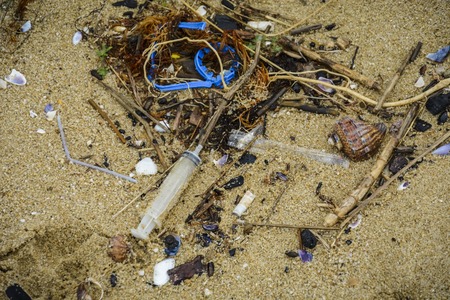 Plastic on the beach with syringe and other plastic garbage
