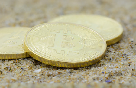 Bitcoins close up on the beach, golden colorの写真素材