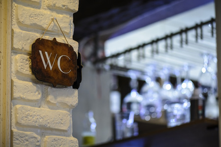Sign on a wall with a Inscription WC , vibrant blue bokehの写真素材
