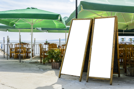 two blank blackboard against chairs and umbrellasの写真素材