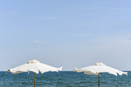 umbrella in front of the sea, blue sky, in summer timeの写真素材