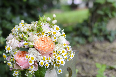 Bridal bouquet with rose, daisy, against forest backgroundの写真素材