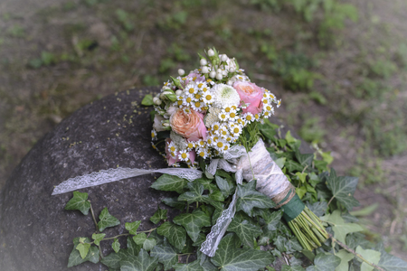 Bridal bouquet with rose, daisy, against forest backgroundの写真素材