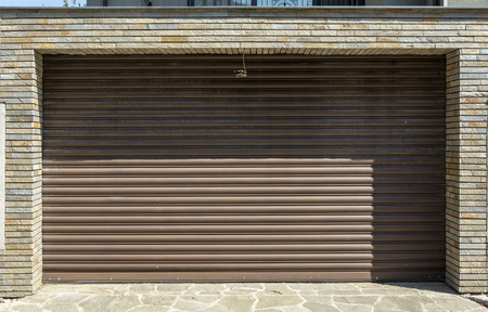 Iron garage door with stone bricks on the side.big shadowの写真素材