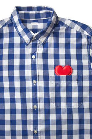 Red heart in blue and white stripe shirt's pocket on isolated white background