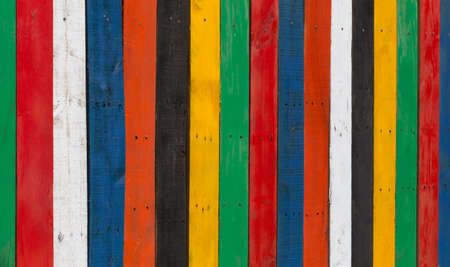 Multi-coloured stripped wooden fence on a sunny day, good for using as background