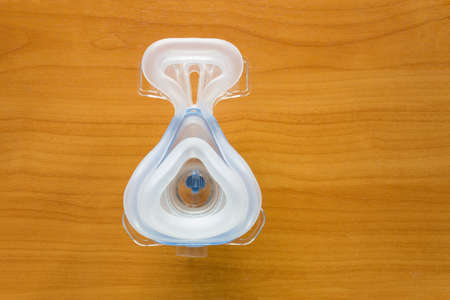 CPAP mask inside facing camera, on wood table