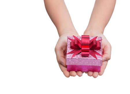 Two female hands holding and presenting a small and shiny pink box of present with shiny red bow on...