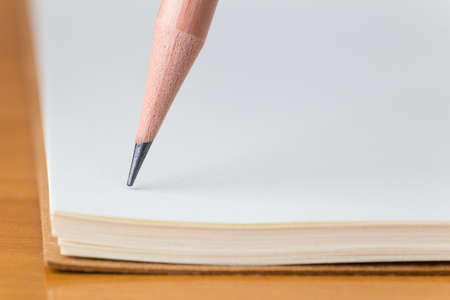 Pencil pointing on blank white notebook, selective focus on pencilの写真素材