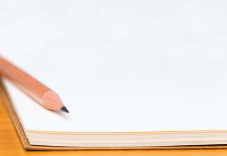 Single pencil on blank white notebook with room for copy space, selective focus on the tip of pencilの写真素材