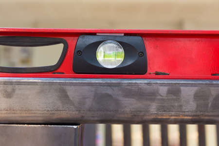 Close up of usded red construction level tool on steel beam, showing bubblesの写真素材