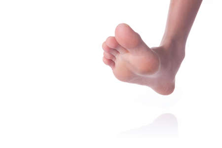Person bare foot walking on white background with reflection and copyspace for textの写真素材