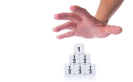Male hand reaching out for white fraction dices, showing third, half, and full numbers, on white...