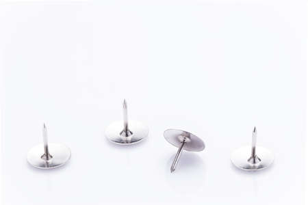 Silver thumbtacks on white backgroun at lower part of the frame, leaving space on top for text or...