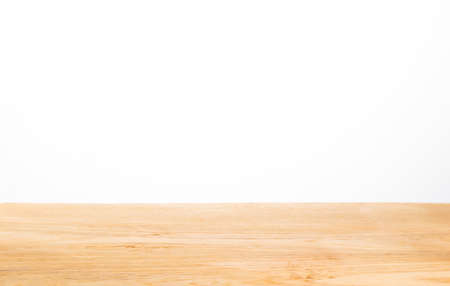 light color wood table top against white background, selective focus on center of the wood table with blurred foreground and backgroundの写真素材