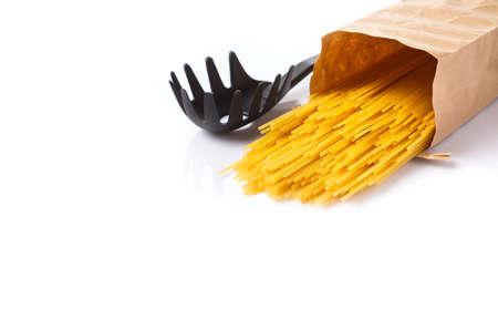 raw spaghetti pasta spill out from paper brown bag on white background with room for copyspace の写真素材