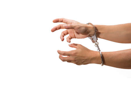 male hands on handcuffs, with white isolated backgroundの写真素材