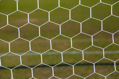 close up of white soccer, or football, net with blurred field background