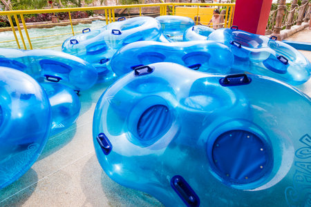Phuket, Thailand - 8 July 2017 - two-person pool inflatable tube floaters pile up and wait for people to use at Splash Jungle water park in Phuket, Thailand on July 8, 2017のeditorial素材