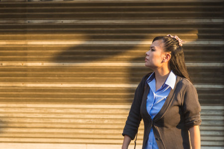 Bangkok, Thailand - 13 September 2017 - Middle aged asian woman waiting for a bus home after work in Bangkok, Thailand on September 13, 2017.のeditorial素材