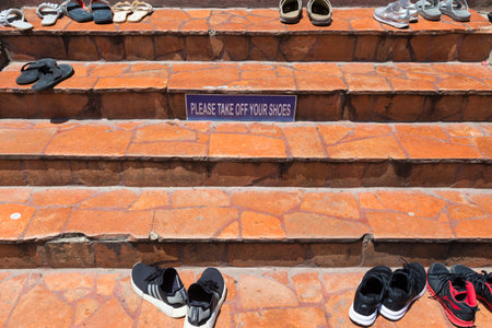 Ayudhaya, Thailand - 14 September 2017 - The Take Off Shoes sign posts on the steps in front of the entrance to a famous temple, Wat Yai Chai Mongkol, in Ayudhaya, Thailand on September 14, 2017.のeditorial素材