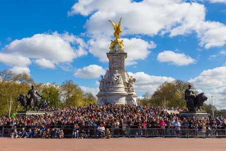 London, England - 10 April 2017 - Tourists from all over the world wait arond the base of Victoria Memorial statue to see the Buckingham Palace guards marching by on April 10, 2017 in London, England.のeditorial素材