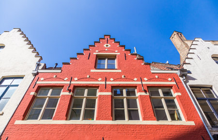 traditional Belgium brick wall building in red and off-white color with unique style top, shown against deep clear blue sky, good for travel and tourism themeのeditorial素材