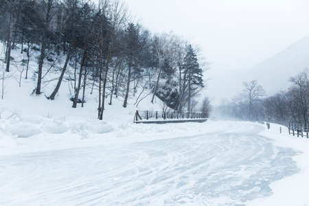 Snow coming down on the road in Daisetsuzan National Park, Hokkaido, Japan, showing beautiful view...