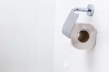 Roll of white toilet paper in a white bathroom, room for textの写真素材