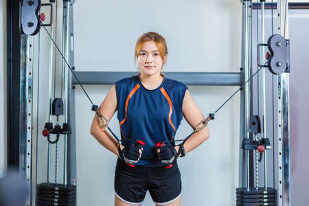 Young Asian woman working out and doing fitness training at a local gym, good for young healthy...