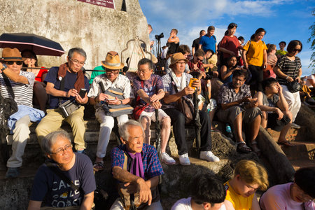 LUANG PRABANG, LAOS - 28 JUNE 2018 - Tourists wait patiently on top of Mount Phousi to see sunset on June 28, 2018 in Luang Prabang, Laosのeditorial素材