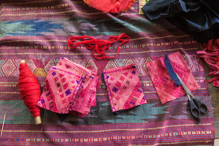 LUANG PRABANG, LAOS - 30 June 2018 - Pieces of hand woven fabric lay on top of a larger piece on a table on June 30, 2018 in Luang Prabang, Laosのeditorial素材