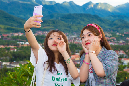 LUANG PRABANG, LAOS - 29 June 2018 - Young Korean tourists take their selfie on top of the Phousi...