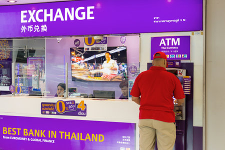 BANGKOK, THAILAND - 21 JULY 2018 - A man gets money from ATM machine at Suvarnaphomi International Airport in Bangkok, Thailand on July 21, 2018のeditorial素材