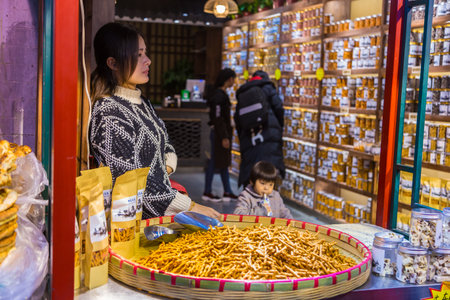 XIAN, CHINA - 10 March 2018 - Chinese female snack seller waits for her customer at her snack shop in Xian, China on March 10, 2018のeditorial素材