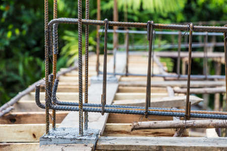 Rebar steels, or reinforced steels, being wire tied together to make frame for concrete beam at a house constructionの写真素材